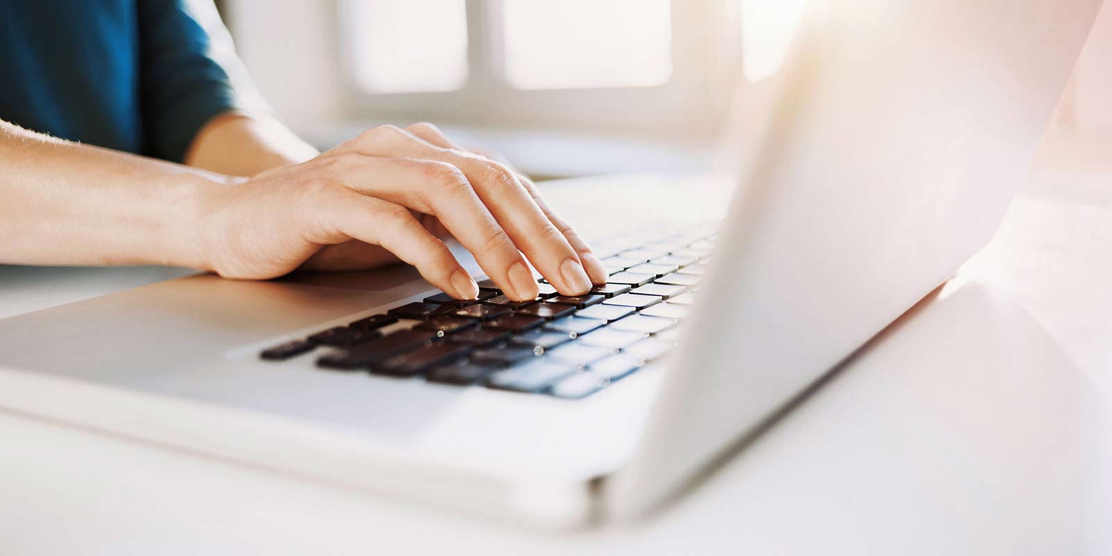 A woman types on her laptop.