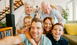 A family huddles together and smiles for a picture.