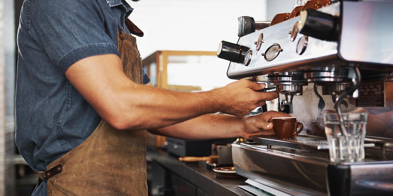 A barista works in a small coffee shop.