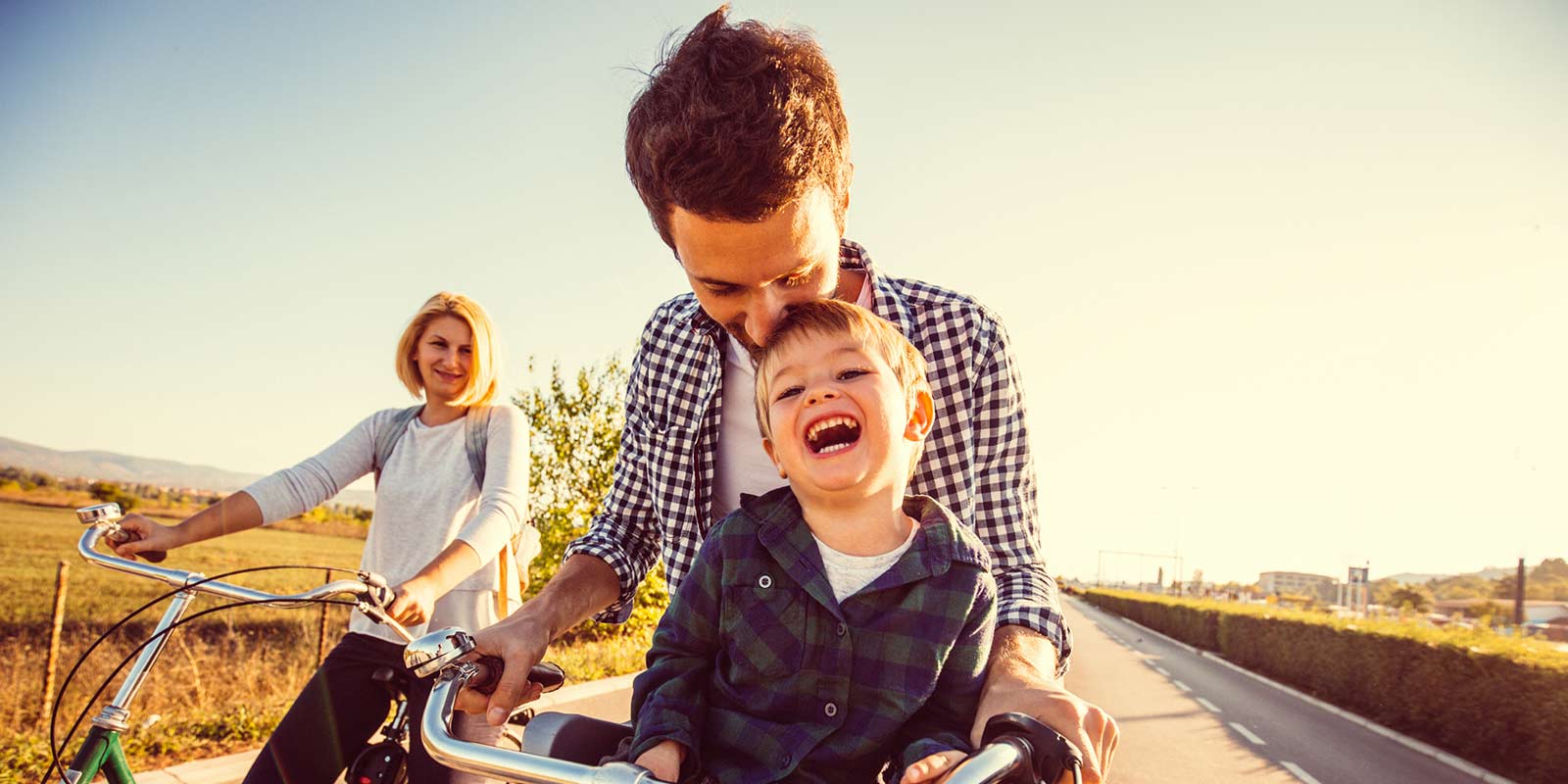 A kids rides on a bike with his father.